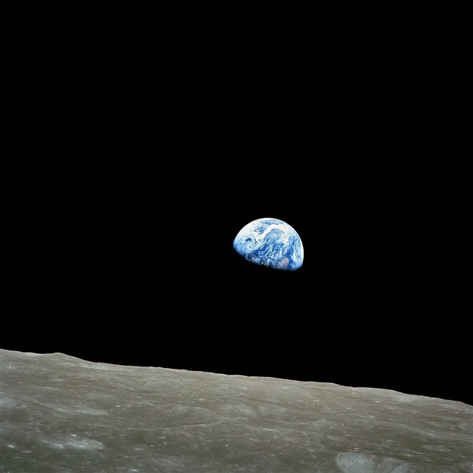 Earth rising above the grey horizon of the Moon, photographed from lunar orbit