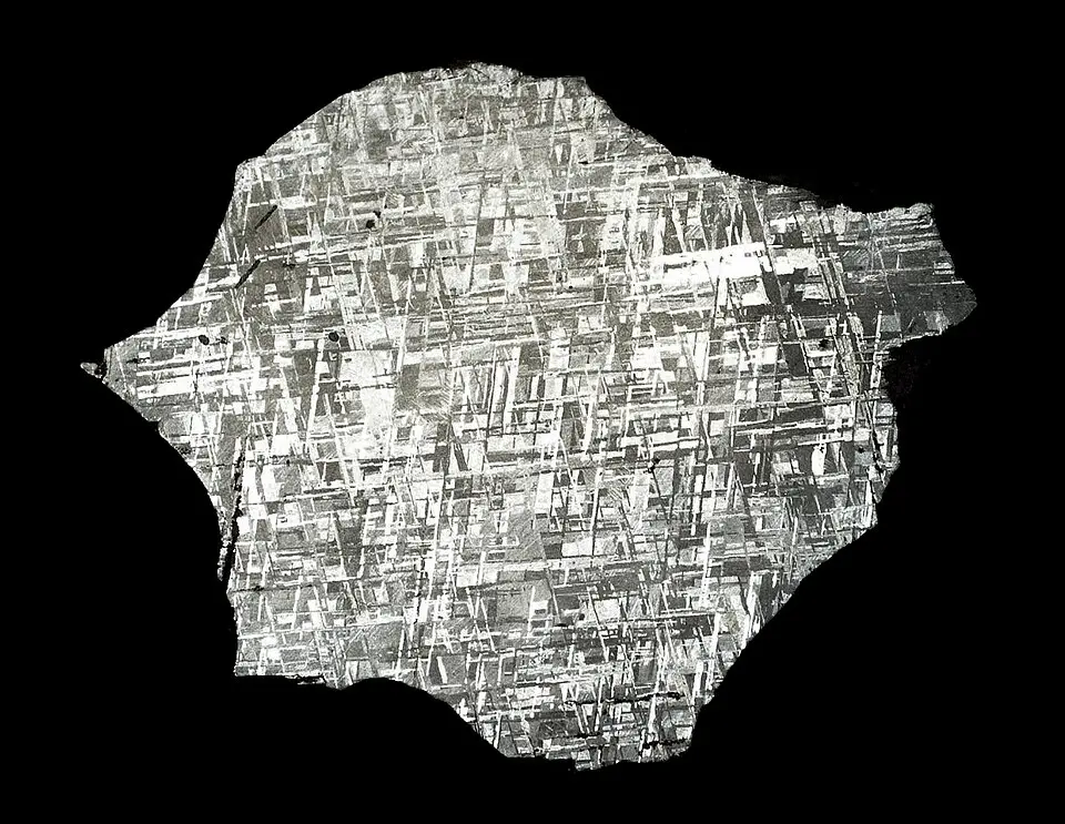 A polished slice of iron meteorite showing a criss-cross crystal pattern