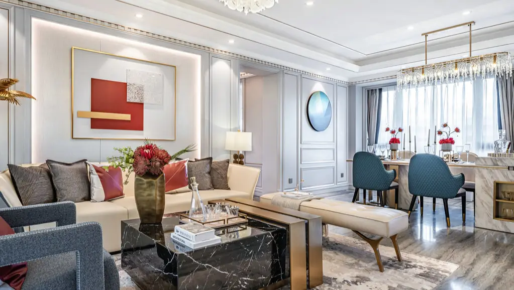 A living and dining room with a framed artwork, a table lamp and a crystal chandelier