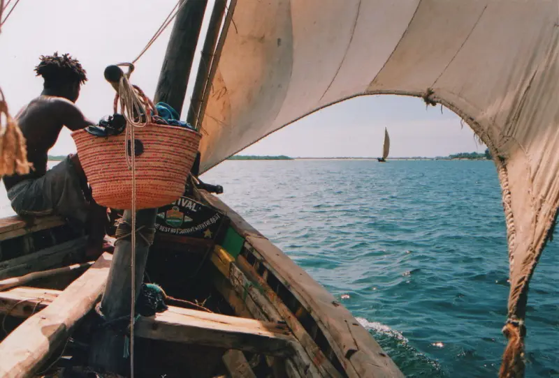 View from inside a sailing dhow across turquoise water near Lamu
