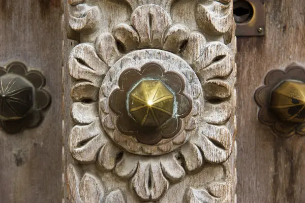 Close-up of a brass boss and carved flower on a Zanzibar door