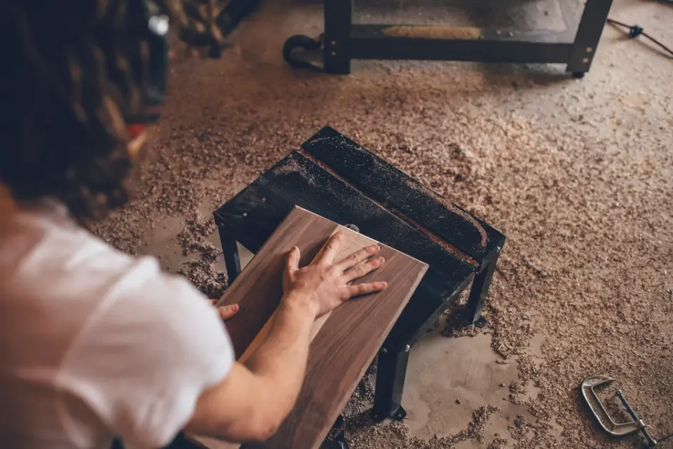 A maker sanding a walnut board by hand
